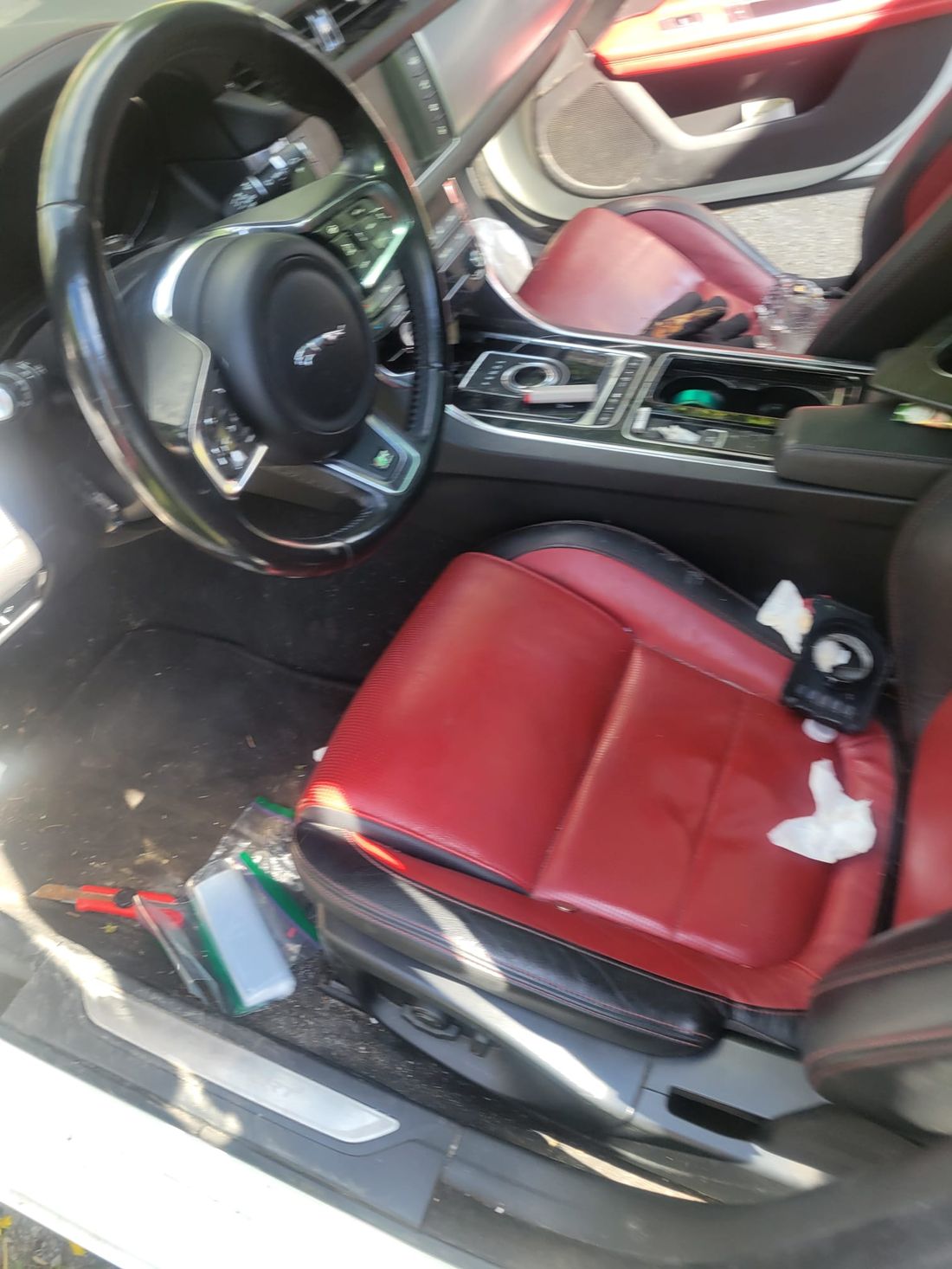 Messy car interior with red leather seats before detailing